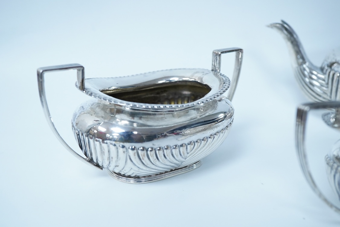 A late Victorian demi-fluted silver oval three piece bachelor's tea set, by James Deakin & Sons, Chester, 1893, gross weight 15.7oz.